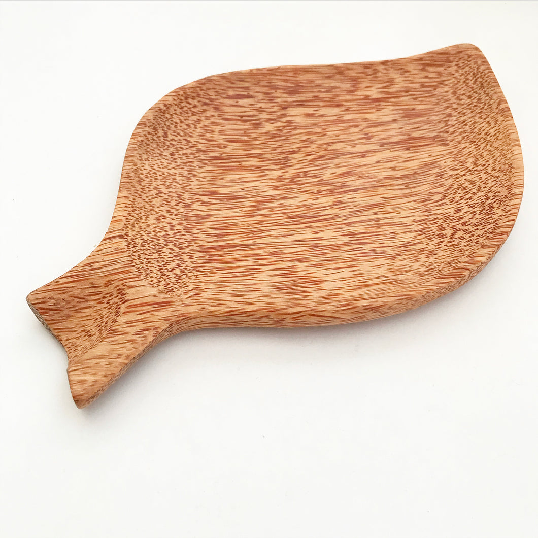 huski home plate made from coconut wood that is shaped like a leaf